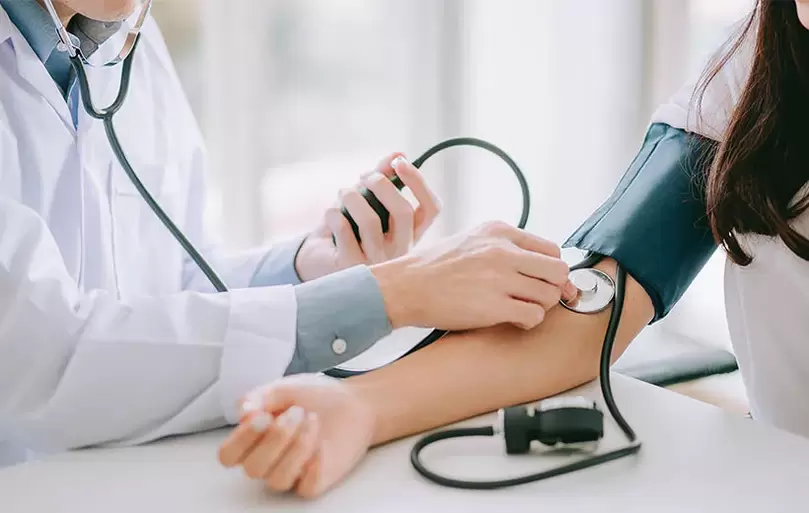 Um cardiologista mede a pressão arterial de um paciente para diagnosticar hipertensão. 